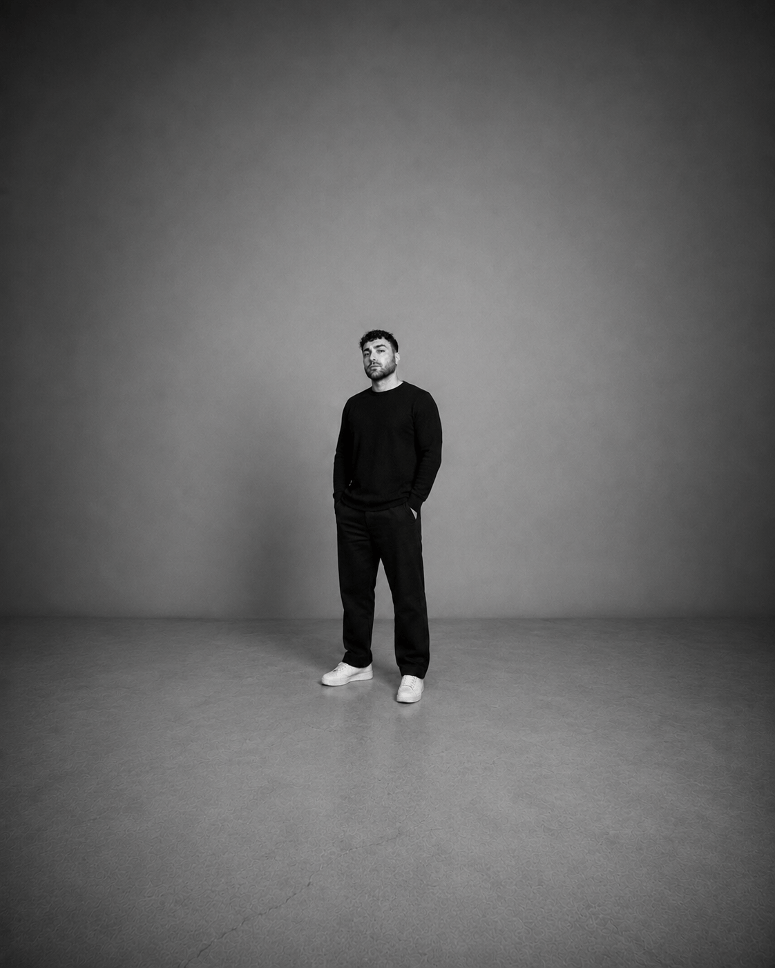 Kadir Demir im Studio stehend in schwarzem Pullover