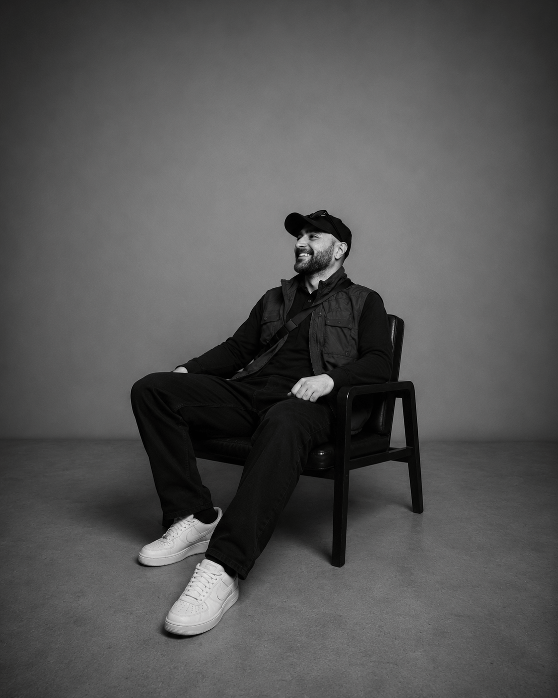 Kadir Demir im Studio sitzend in schwarzer Kleidung