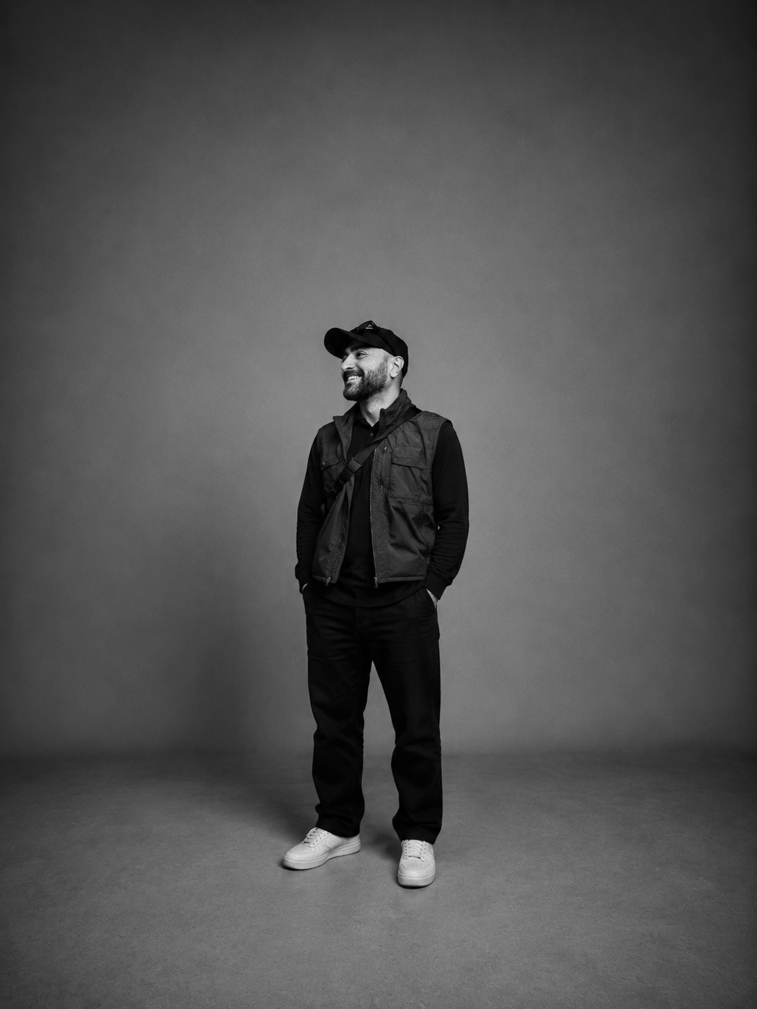 Kadir Demir im Studio stehend mit schwarzer Weste und Cap