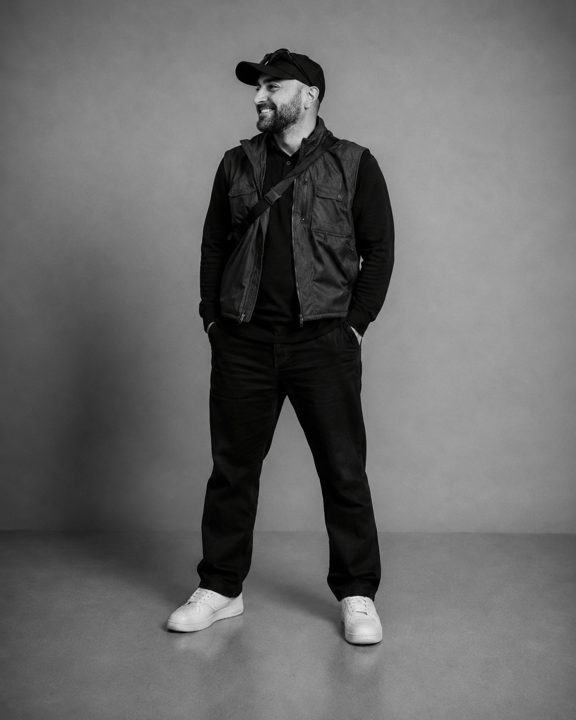 Studio-Porträt von Kadir Demir mit schwarzer Weste und Cap