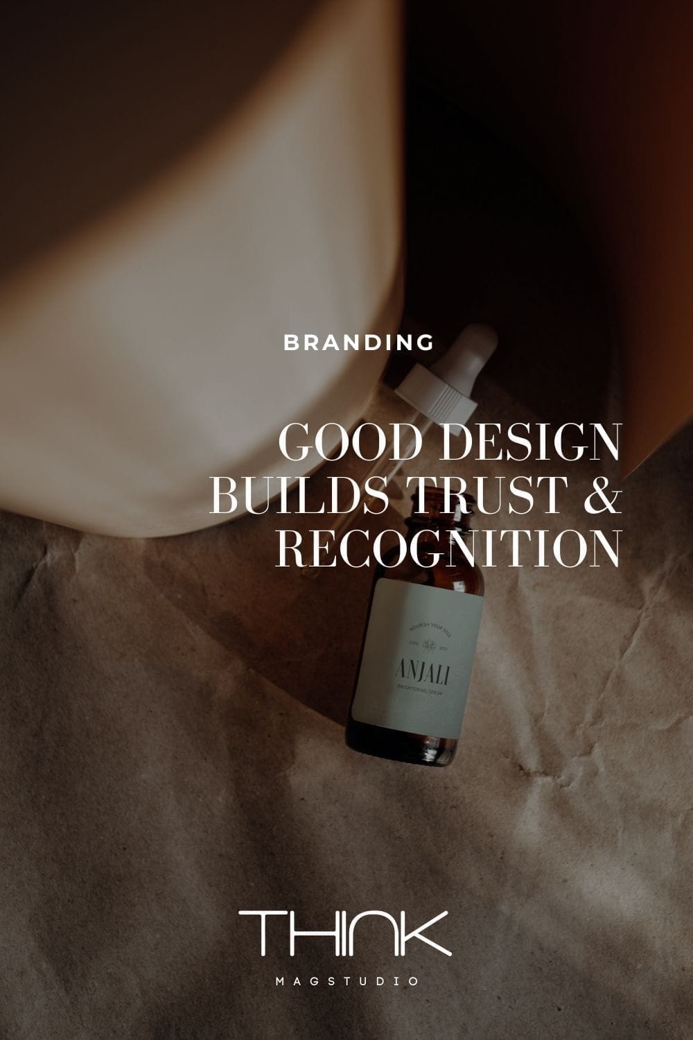 amber glass skincare dropper bottle labeled anjali placed on kraft paper with soft shadows. text overlay reads good design builds trust & recognition thinkmagstudio branding