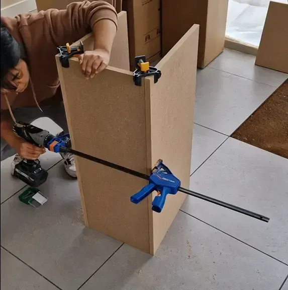 coach en bricolage diy qui perce des planches pour créer un meuble