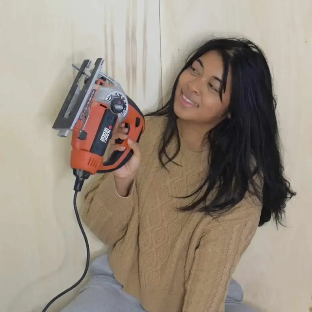 coach en bricolage et diy qui tient une ponçeuse