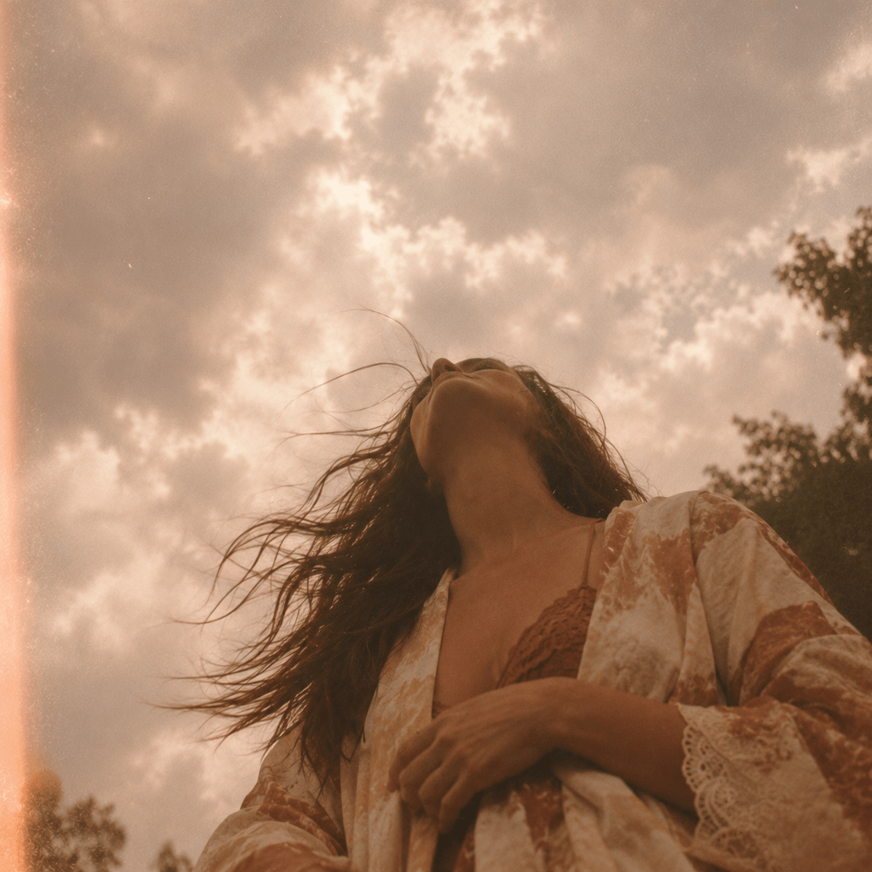 Femme rêveuse sous un ciel nuageux