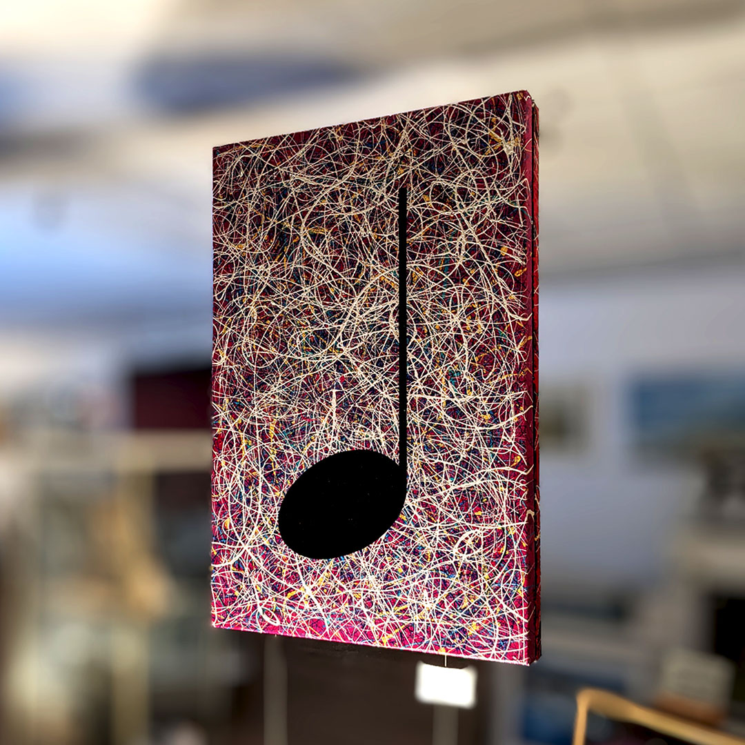 Pink music graffiti painting hanging in a gallery window in Saffron Walden