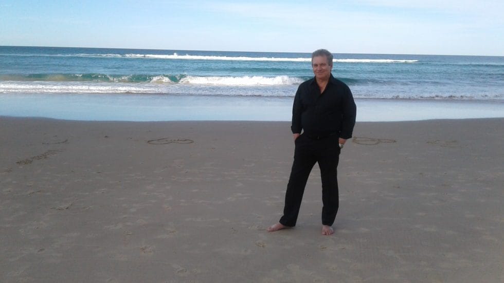 John Roberts on the beach barefoot