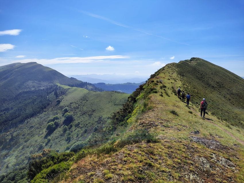 Caminando por un cordal de montaña con amplias vistas al horizonte y sensación de libertad, ilustrando el concepto de espacio mental frente al cansancio psicológico.