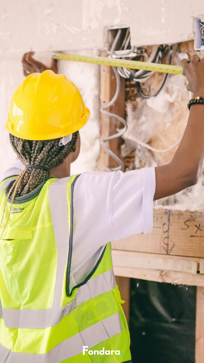 Artisan du bâtiment prenant des mesures sur chantier — précision et organisation commerciale BTP