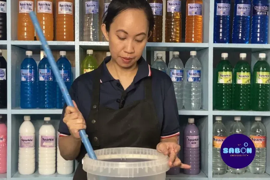 Filipino entrepreneur making homemade soap and cleaning supplies to save business costs.
