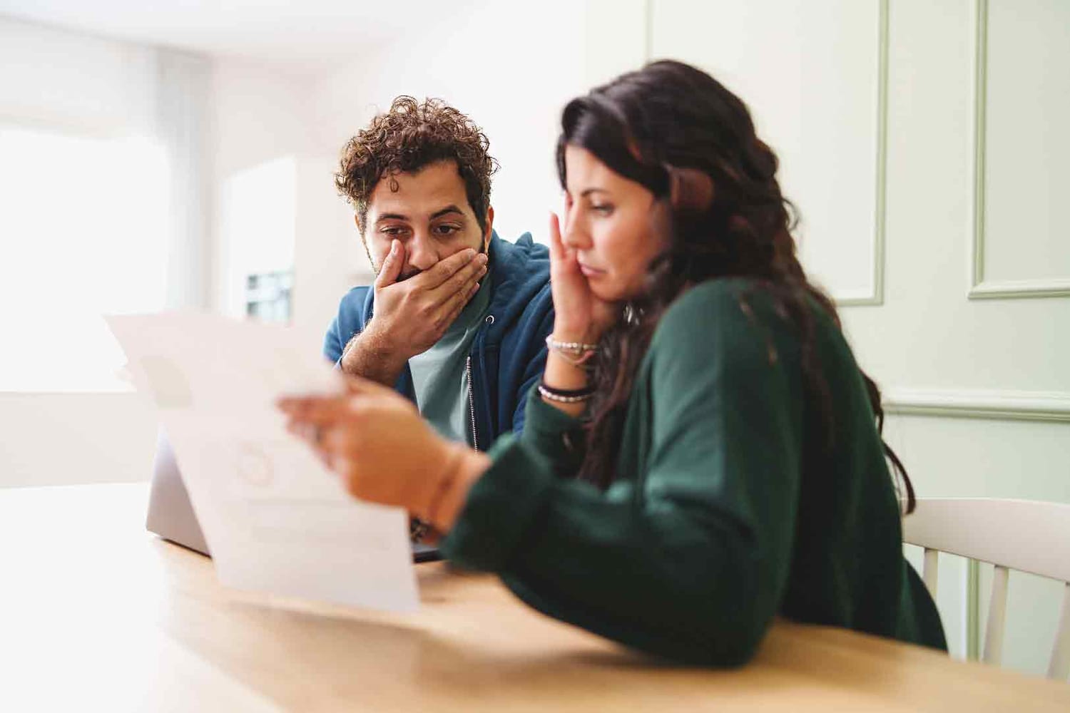 Jeune couple visiblement inquiet par le montant d'une facture.