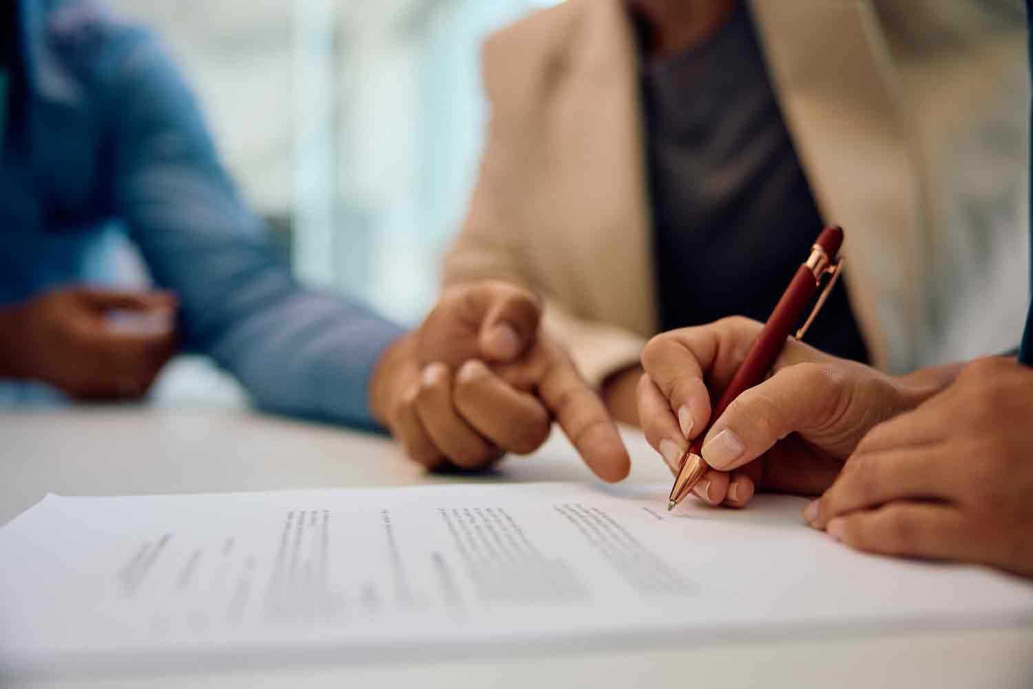 Un couple s apprête à signer des documents de vente sous les conseil du vendeur 