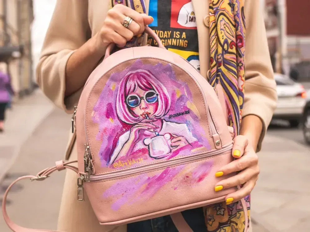 Detailaufnahme mit pinkhaariger Frau bemalter Rucksack und Streetstyle-Outfit