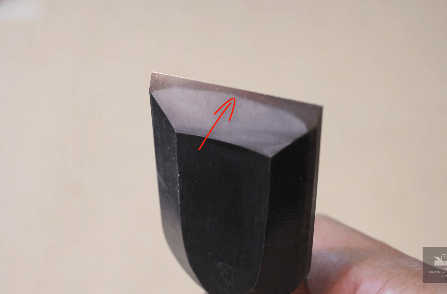 Cross-section diagram of a Japanese chisel (nomi) showing laminated high-carbon steel and soft iron layers