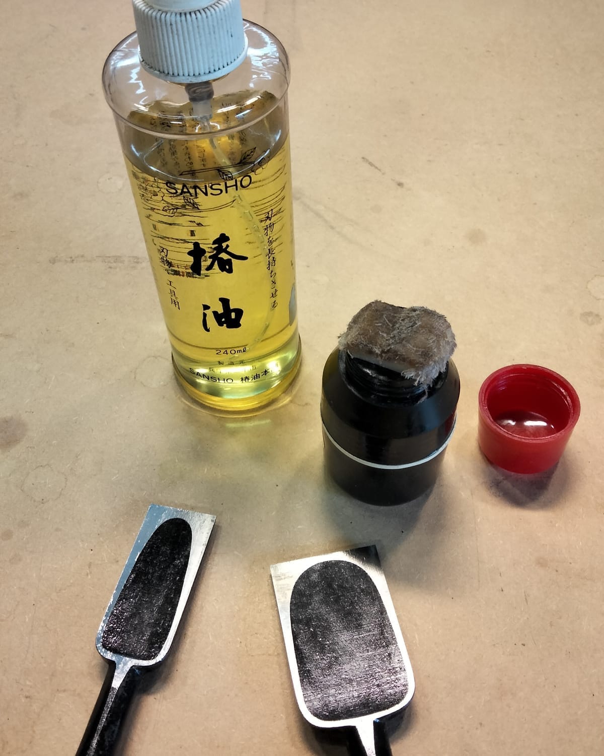Bottle of camellia oil and chisels with a light coat applied