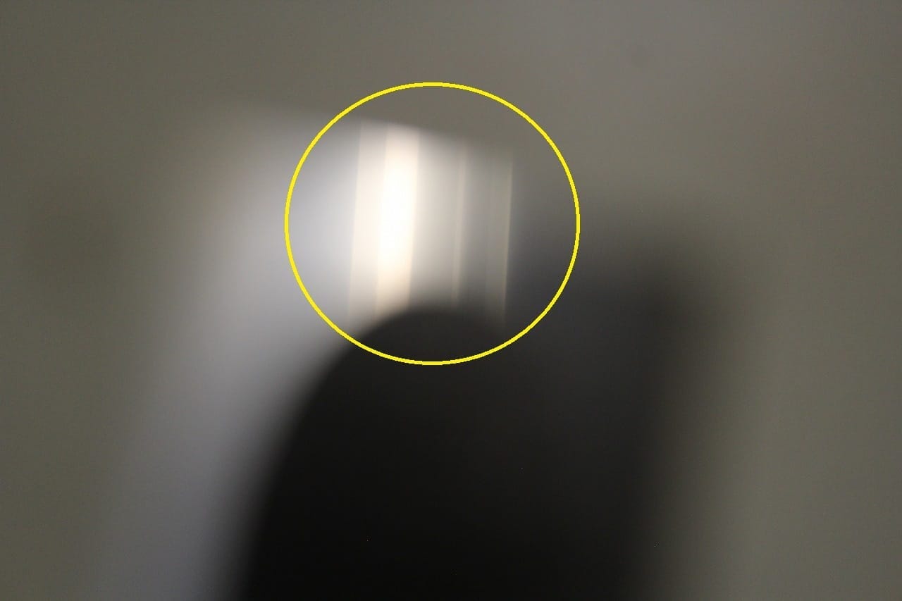 Fluorescent light reflected straight across the flattened backside.