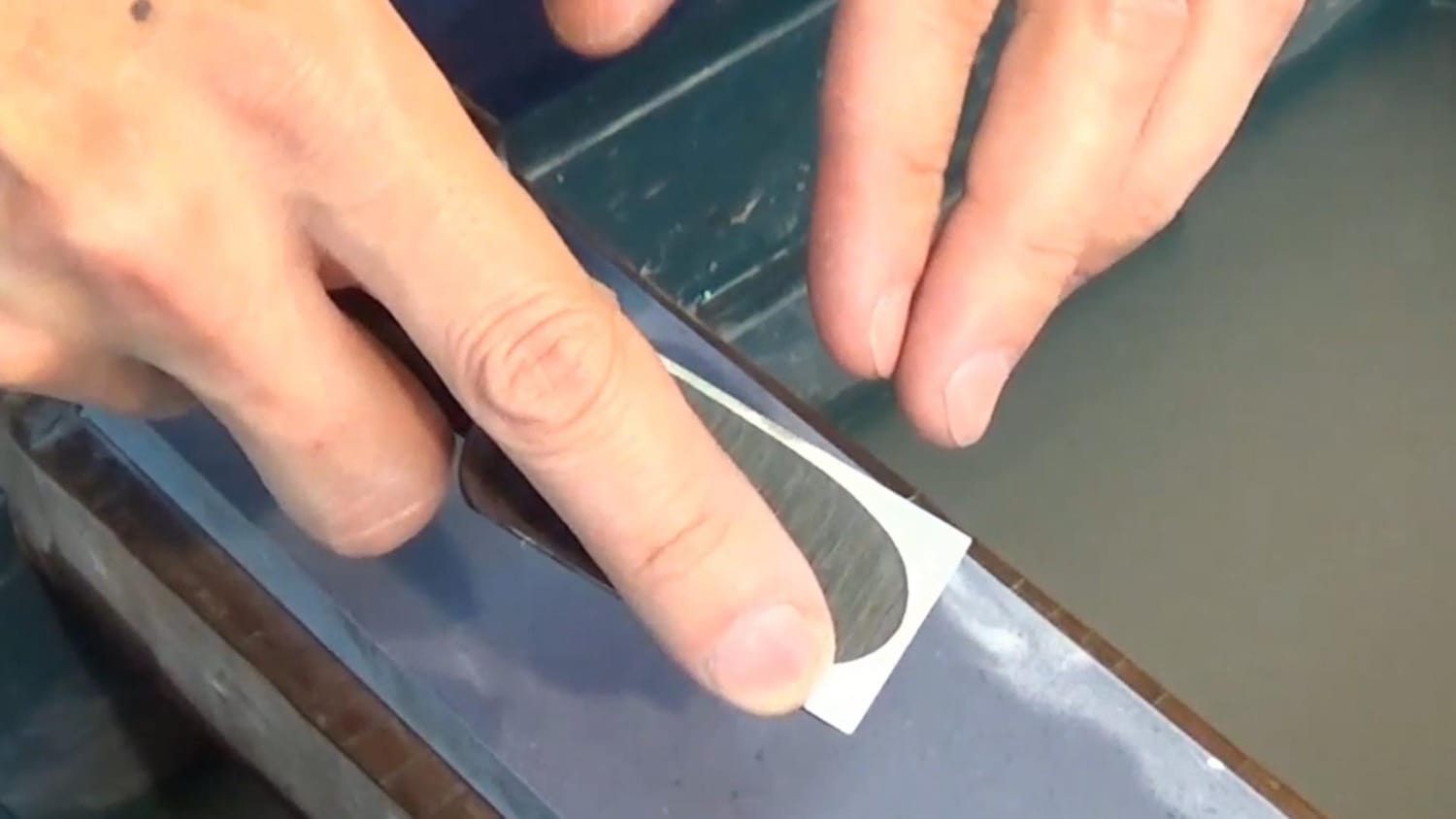 Proper hand position when sharpening a Japanese chisel: grip the handle firmly and place the index finger on one corner of the blade.