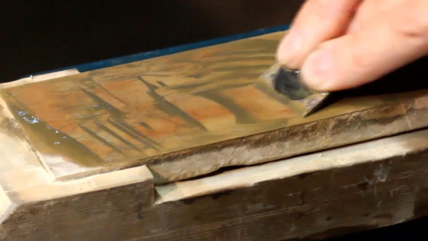 Macro shot of slurry with dark streaks forming behind a chisel’s cutting edge.