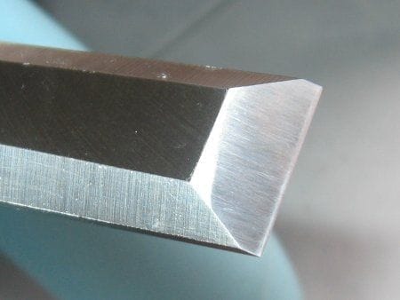 A set of Western bench chisels with visible micro-bevels on their cutting edges.