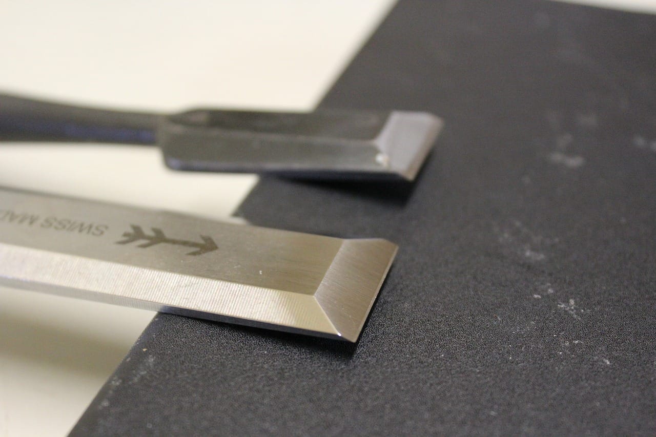 Japanese and Western chisels placed side by side, showing how their cutting edges are shaped differently.