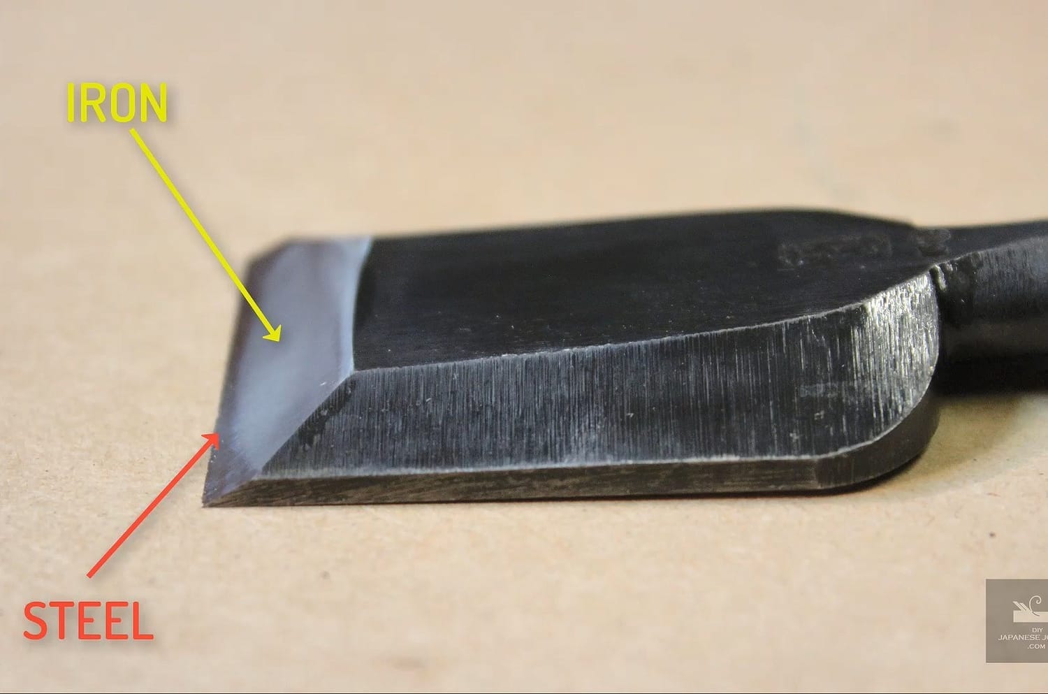 Japanese chisel blade close-up, highlighting the laminated construction with a soft iron body and hard steel cutting edge.