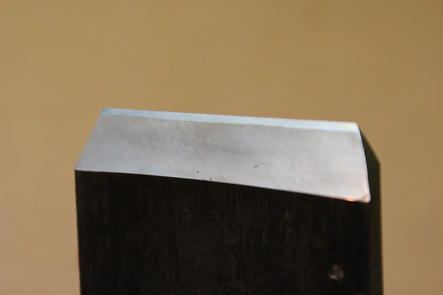 Close-up of a Japanese plane blade showing a straight, clean weld line between steel and soft iron.