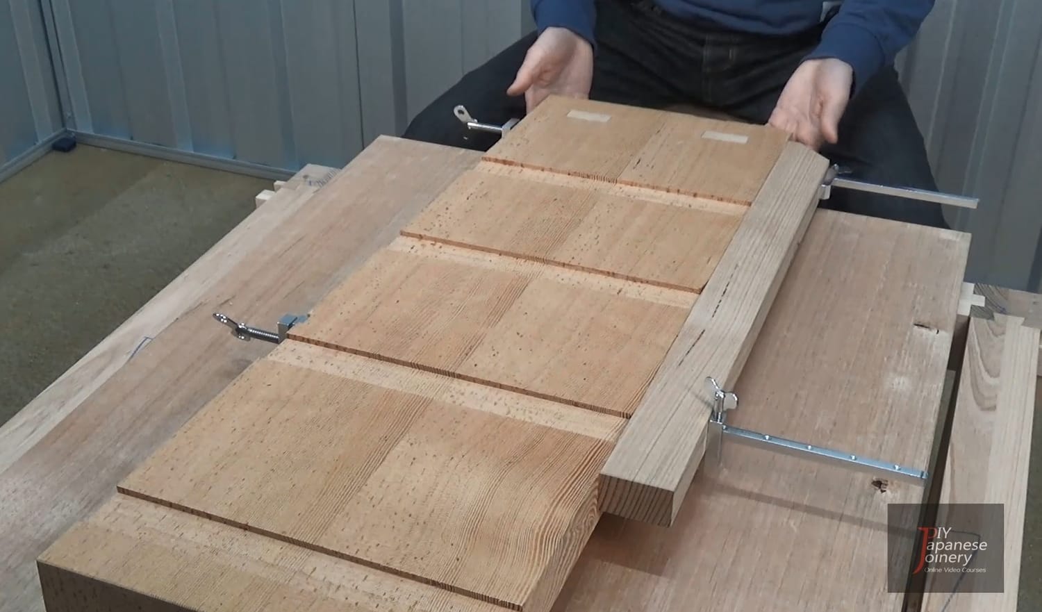 Planing board secured with clamps to a dining table, used as a temporary workbench.