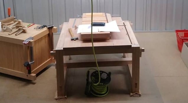 A modest living room transformed into a woodworking space with hand tools.