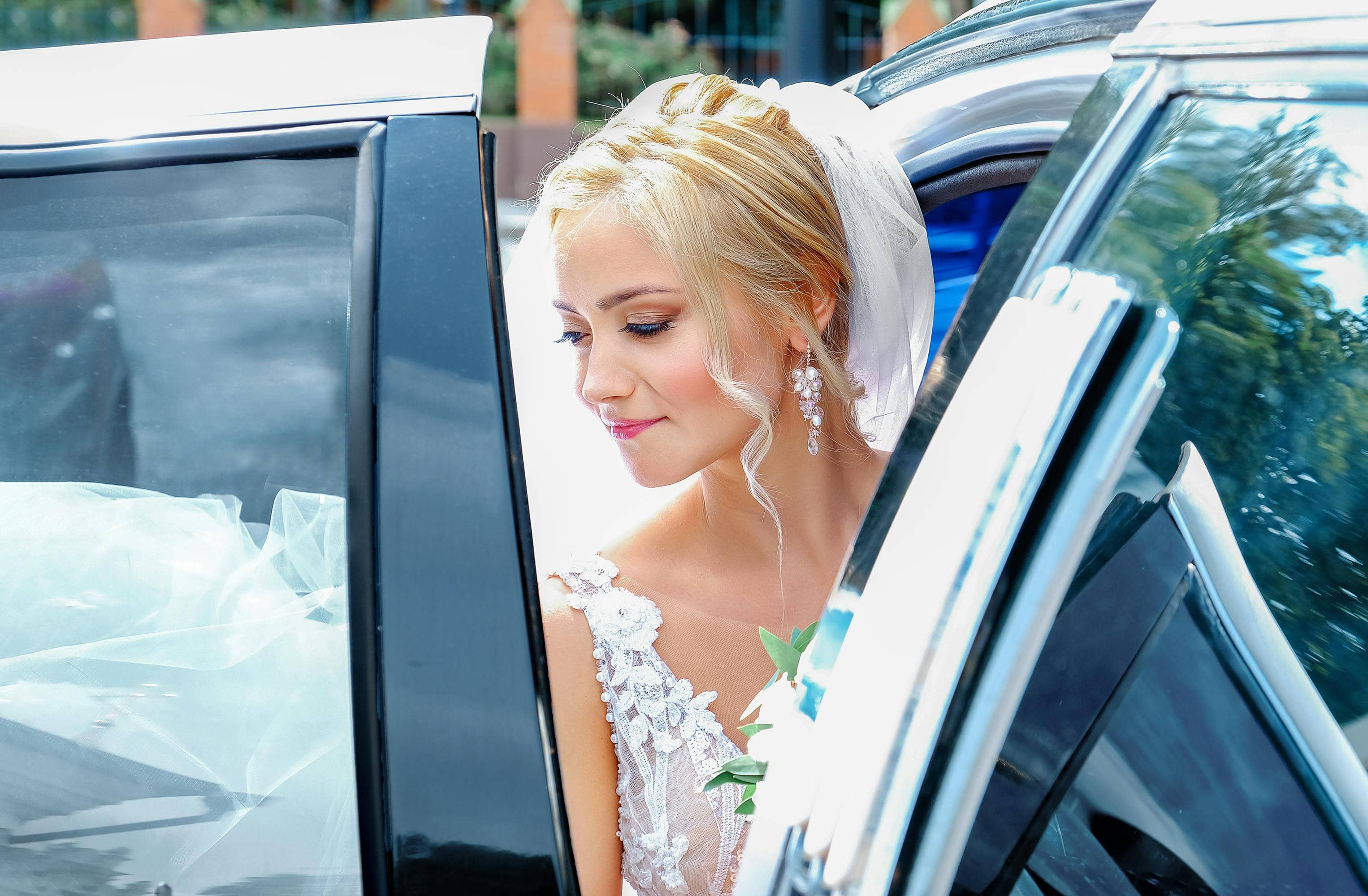 mariée sortant d'une voiture de mariage