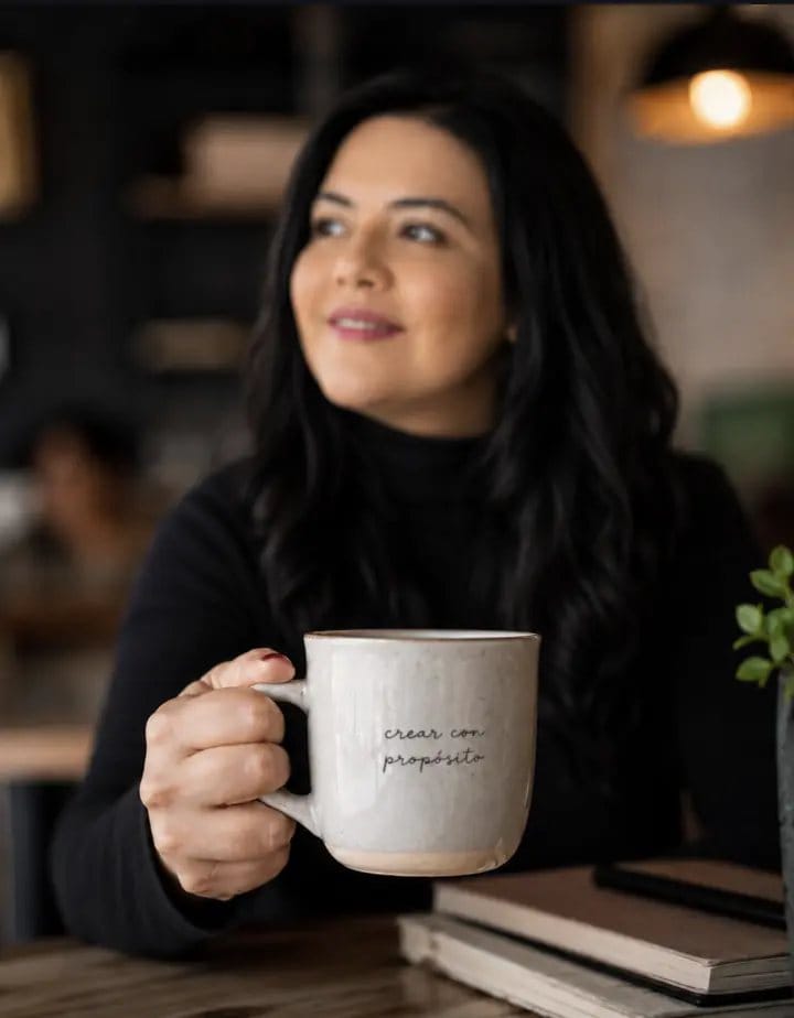 Leyla Ruiz con una taza que dice crear con propósito
