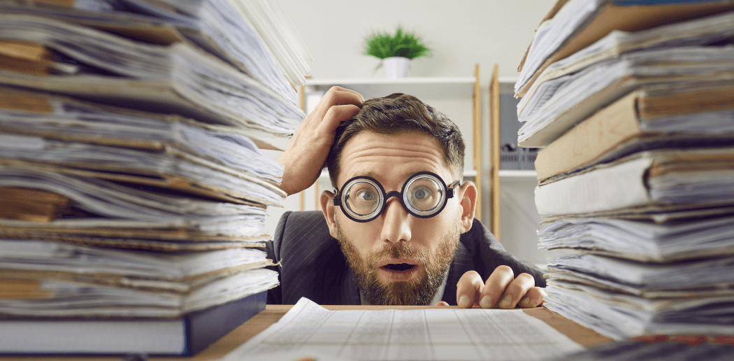 man surrounded by piles of paper