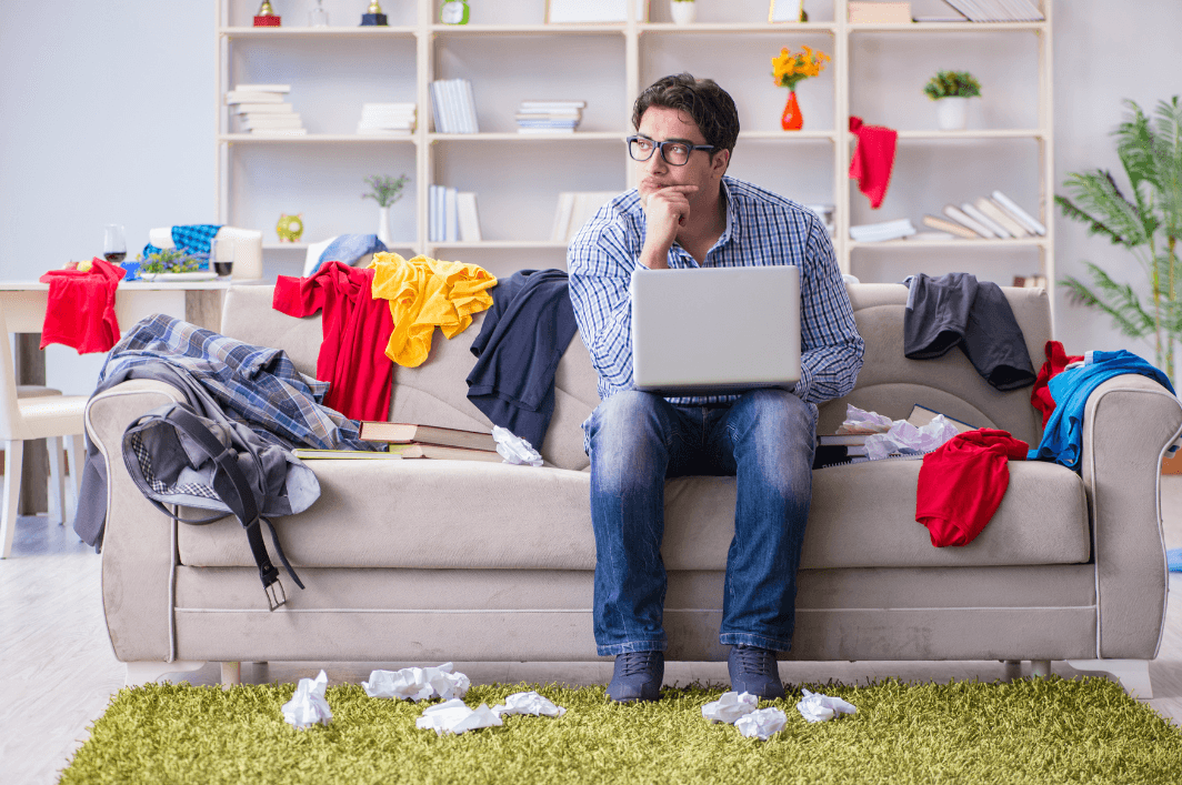 man trying to work in untidy room