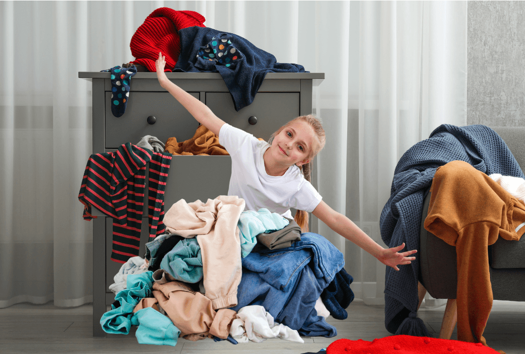 young woman amongst cluttered clothes