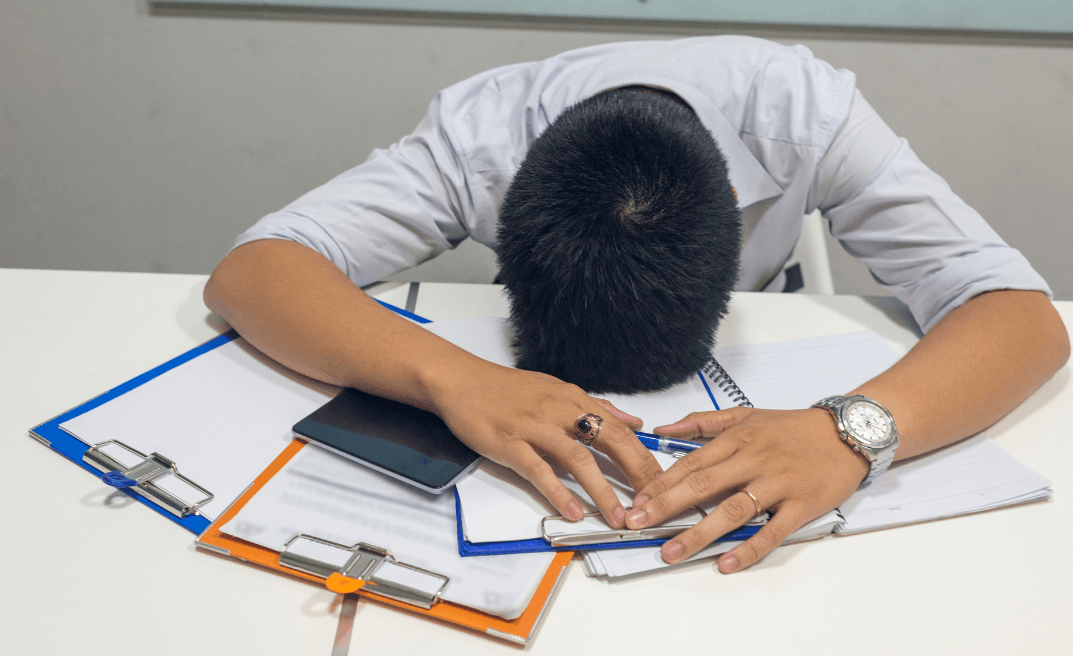 man slumped over desk