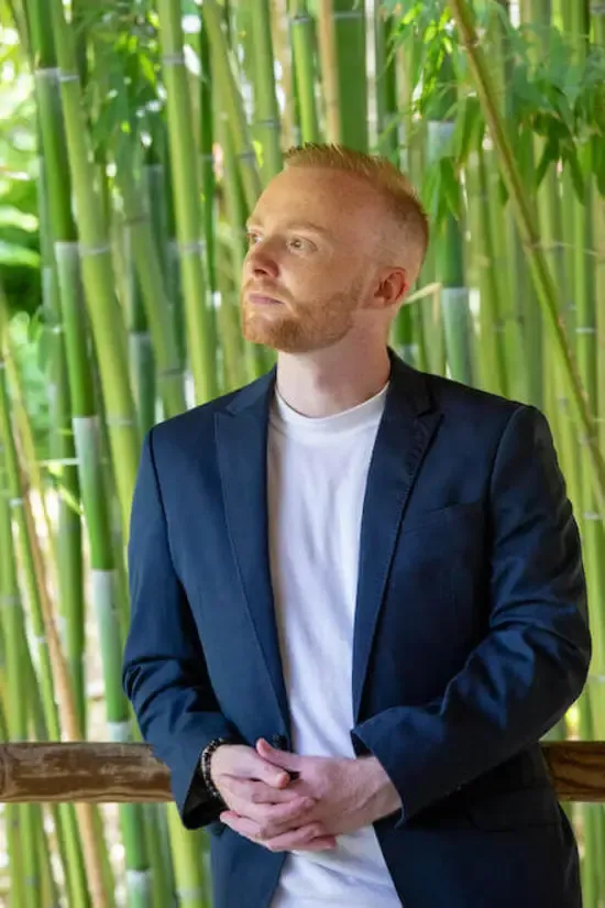 Jean-Luc Ratiskol, coach en développement spirituel, regard tourné vers l'horizon dans un jardin de bambous