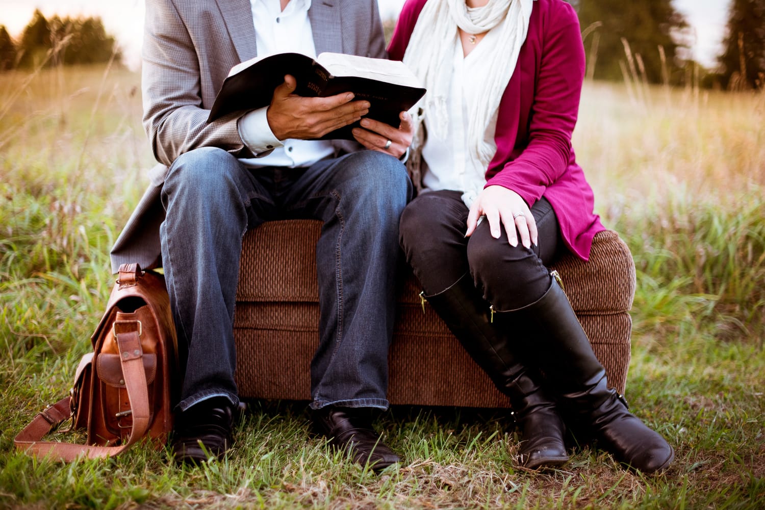 Man and woman reading Bible heads not shown
