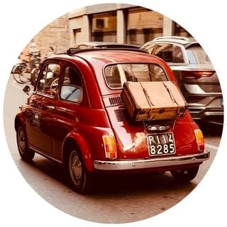 A red car on a cobblestone street in Florence - Solo Seasons category on Midlife in Italy blog