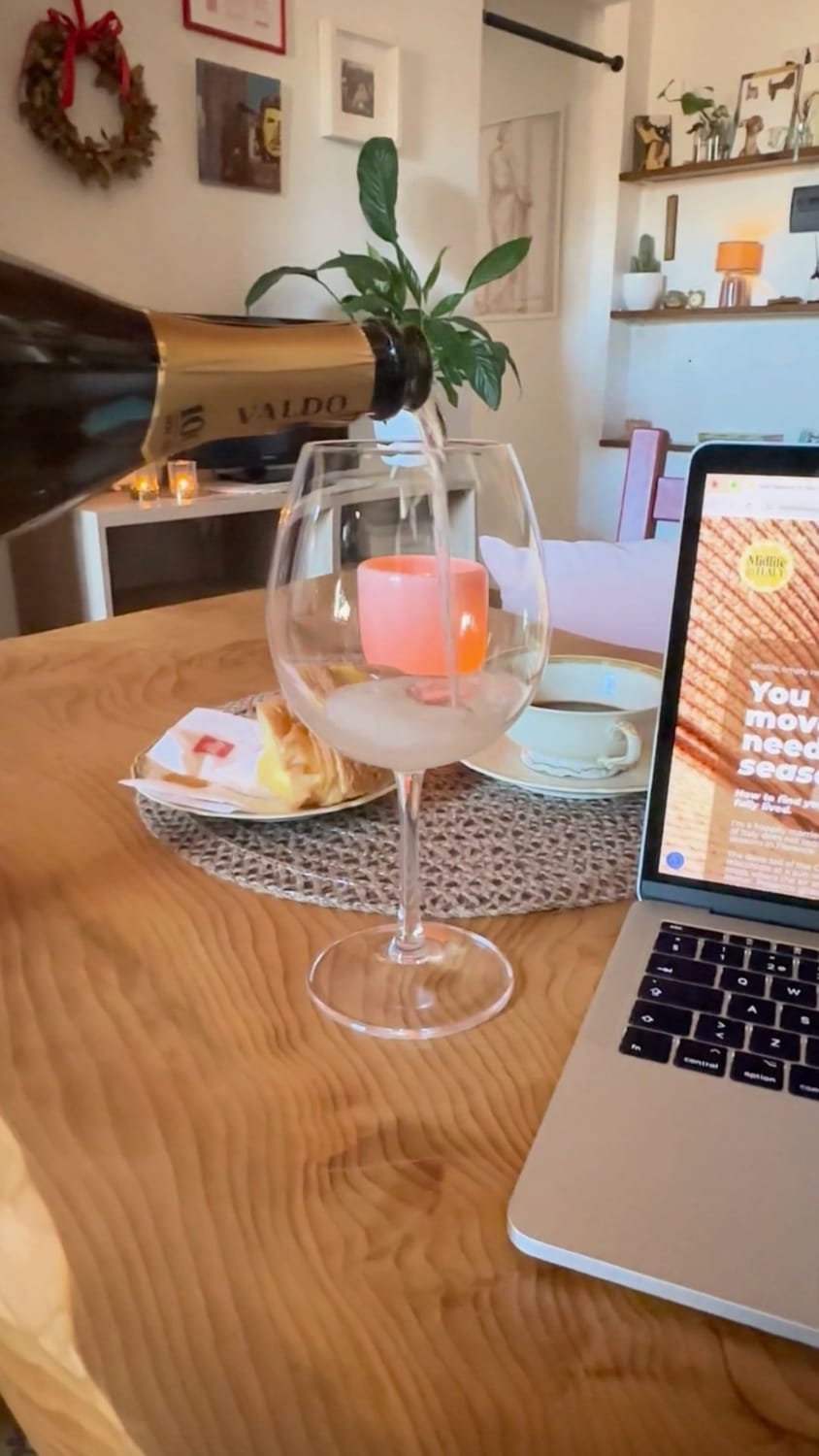A chilled glass of Prosecco catching the spring sunlight in a Florentine attic office, celebrating a midlife business launch.