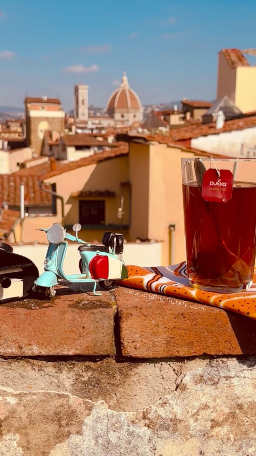 Pukka tea in a glass on a sunlit Florence rooftop terrace with a view of the Duomo, representing the freedom of a Handbag Office and midlife entrepreneurship.
