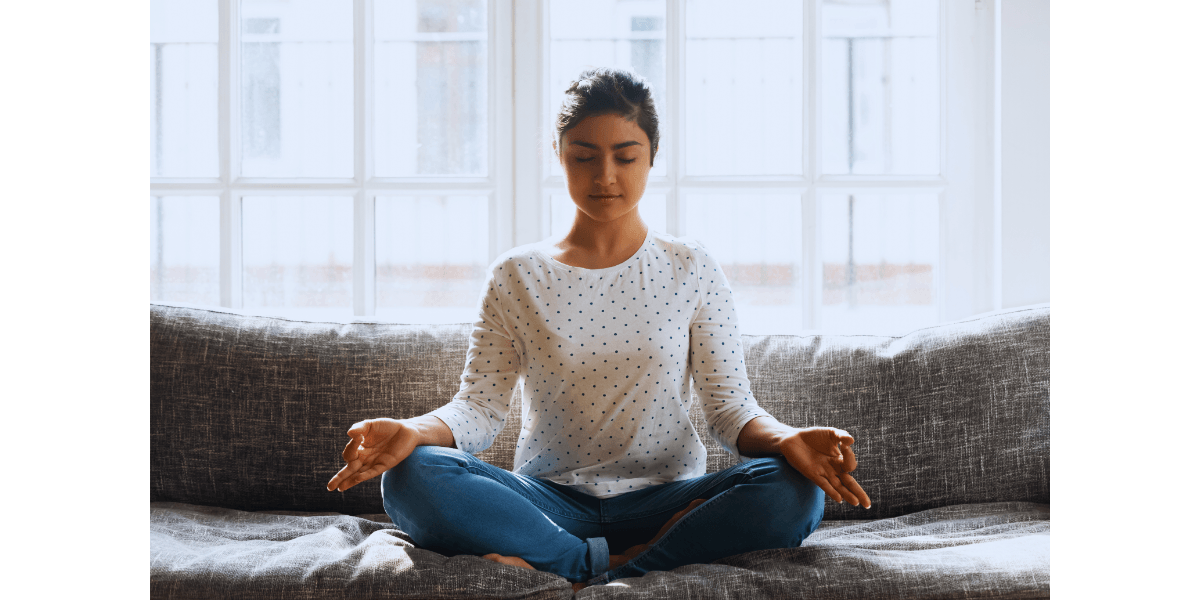 woman in a seated yoga pose with thinmb and forefinger touching