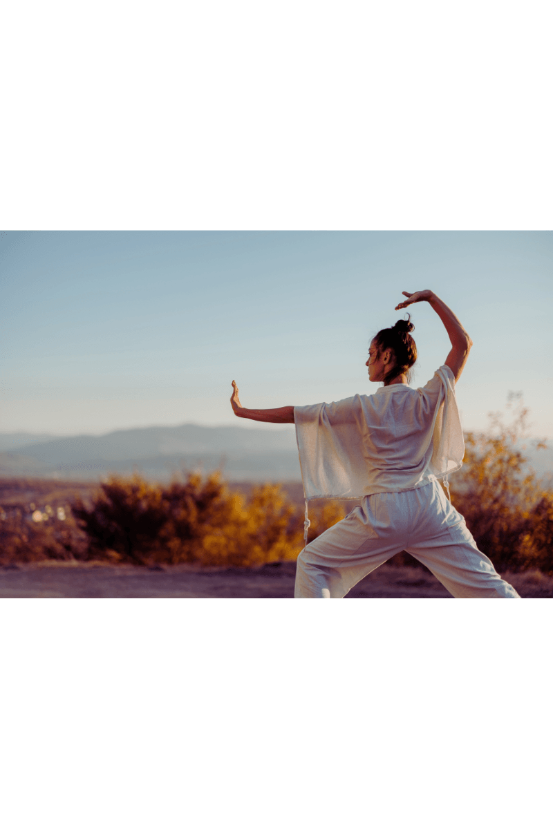 woman with arm outsretched for a block and arm raised above wearing white flow outfit