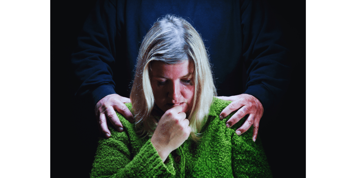 woman looking down with man's hands on her shoulder-silent abuse