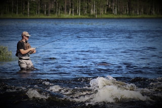 Man in a rushing river fly-fishing.