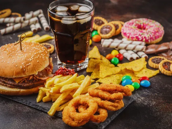 Photo of ultra-processed foods like sugary snacks, white bread, and fizzy drinks