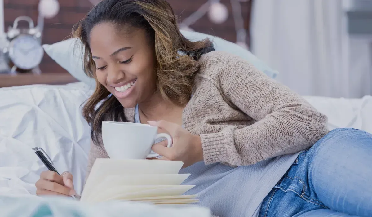 Woman on a 28-Day Gut Reset for rosacea, tracking progress and enjoying gut-healing tea