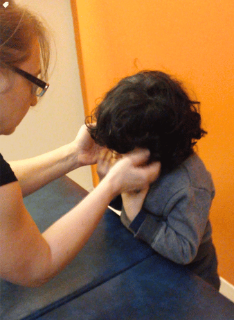 a woman therapist treating a boy child with qigong sensory massage therapy