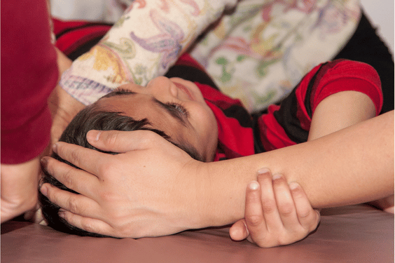 autistic child receiving qigong sensory therapy massage treatment
