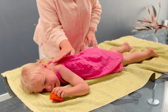 autistic child receiving qigong sensory therapy massage treatment