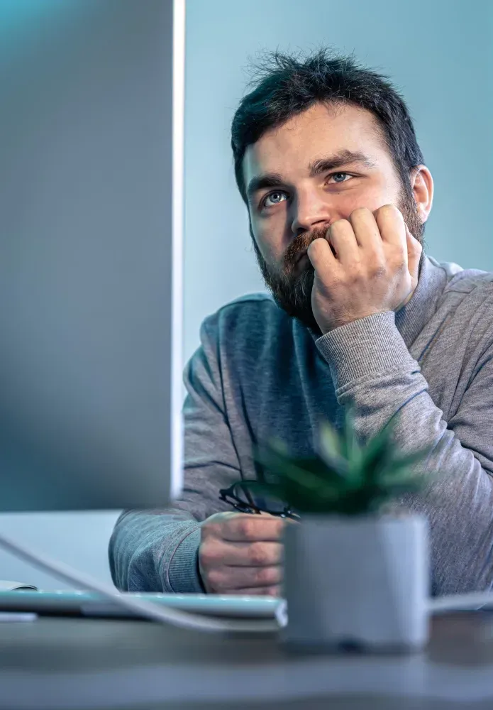 Dirigeant de SASU stressé devant son ordinateur en gérant sa comptabilité.