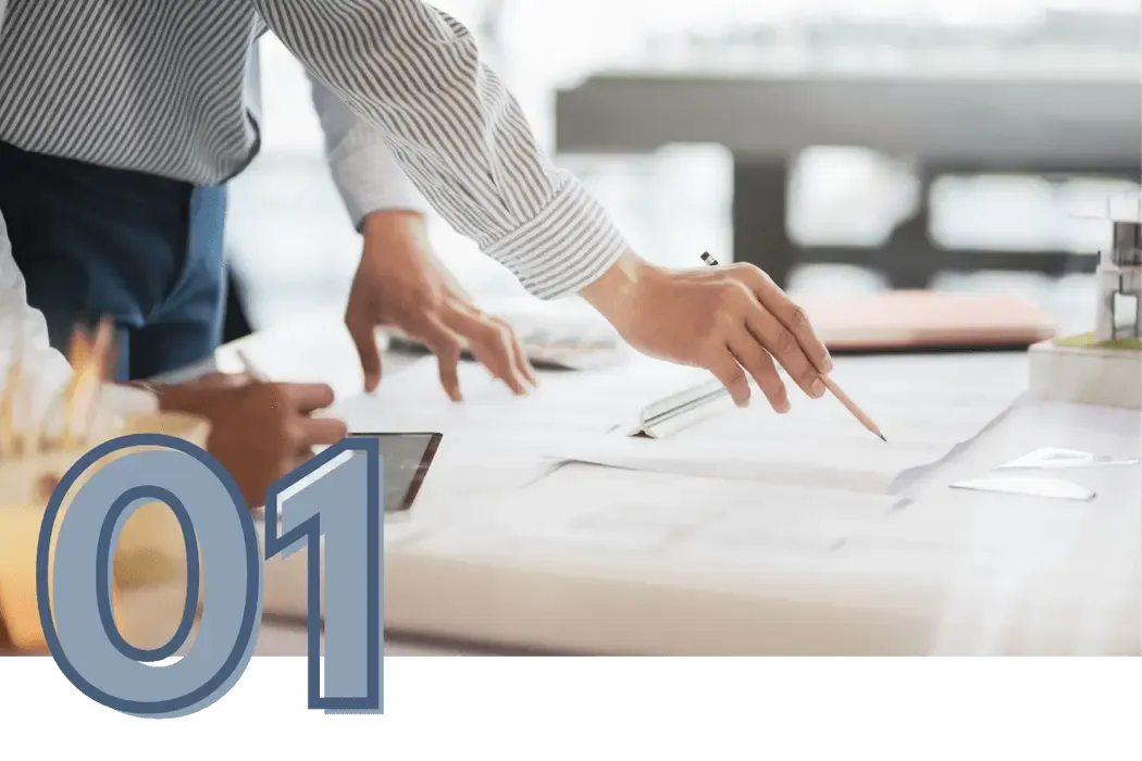 Two professionals reviewing detailed project blueprints and financial plans on a large desk, illustrating effective business growth strategies and collaborative planning.