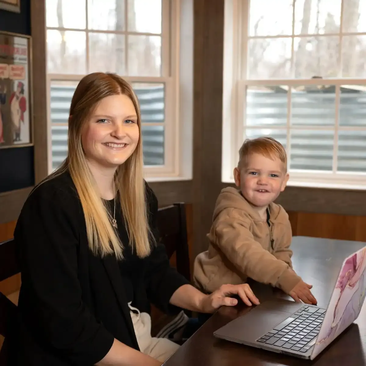 Courtney, a professional team member working from a home office with her child, highlighting the flexibility and life-centered results of business growth consulting.